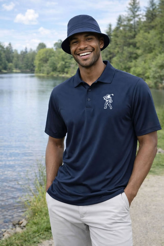 Man wearing a navy astronaut golf polo shirt by a lake