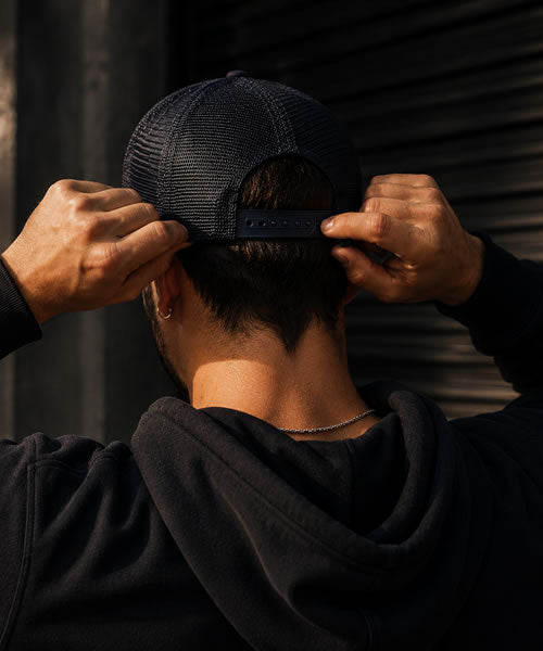 Person adjusting the fit of a trucker hat